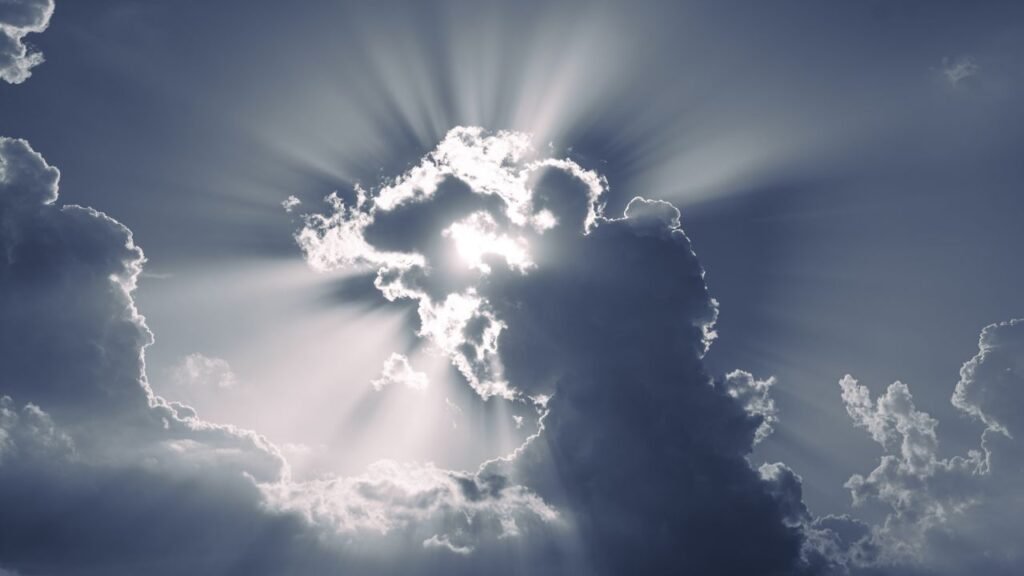 Sunlight streaming through dramatic clouds creating a heavenly effect in the sky.